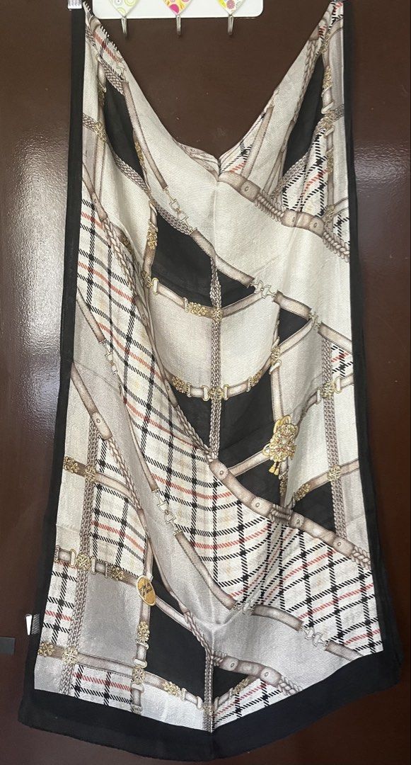 DAKS Scarf Silk Blend Tartan Chain Print (Category: Scarves) located in Cebu City. Submitted by 7paws (Listing ID 1440377420, Image 1). Description: - Classic DAKS scarf - Features tartan and chain print - Black border detail - Material feels like a silk blend - Approximate measurements: 35 x 35 inches - A versatile accessory to elevate any outfit.