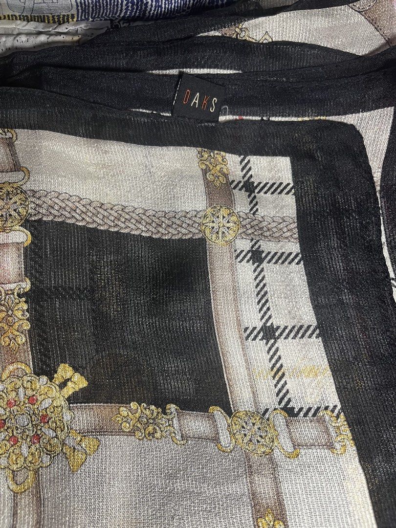 DAKS Scarf Silk Blend Tartan Chain Print (Category: Scarves) located in Cebu City. Submitted by 7paws (Listing ID 1440377420, Image 3). Description: - Classic DAKS scarf - Features tartan and chain print - Black border detail - Material feels like a silk blend - Approximate measurements: 35 x 35 inches - A versatile accessory to elevate any outfit.