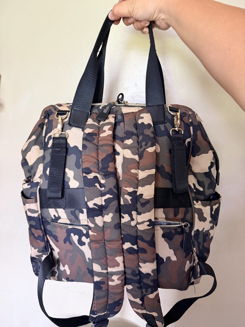 Diaper Bag Camouflage Backpack with Multiple Pockets (Category: Diaper Bags & Wetbags) located in Malolos. Submitted by findandmore (Listing ID 1440331590, Image 2). Description: - Stylish camo print backpack - Multiple pockets for excellent organization - Spacious main compartment - Convenient side pockets - Adjustable straps for a comfortable fit - Zippers have some wear, as pictured - Ideal for everyday use or travel adventures.