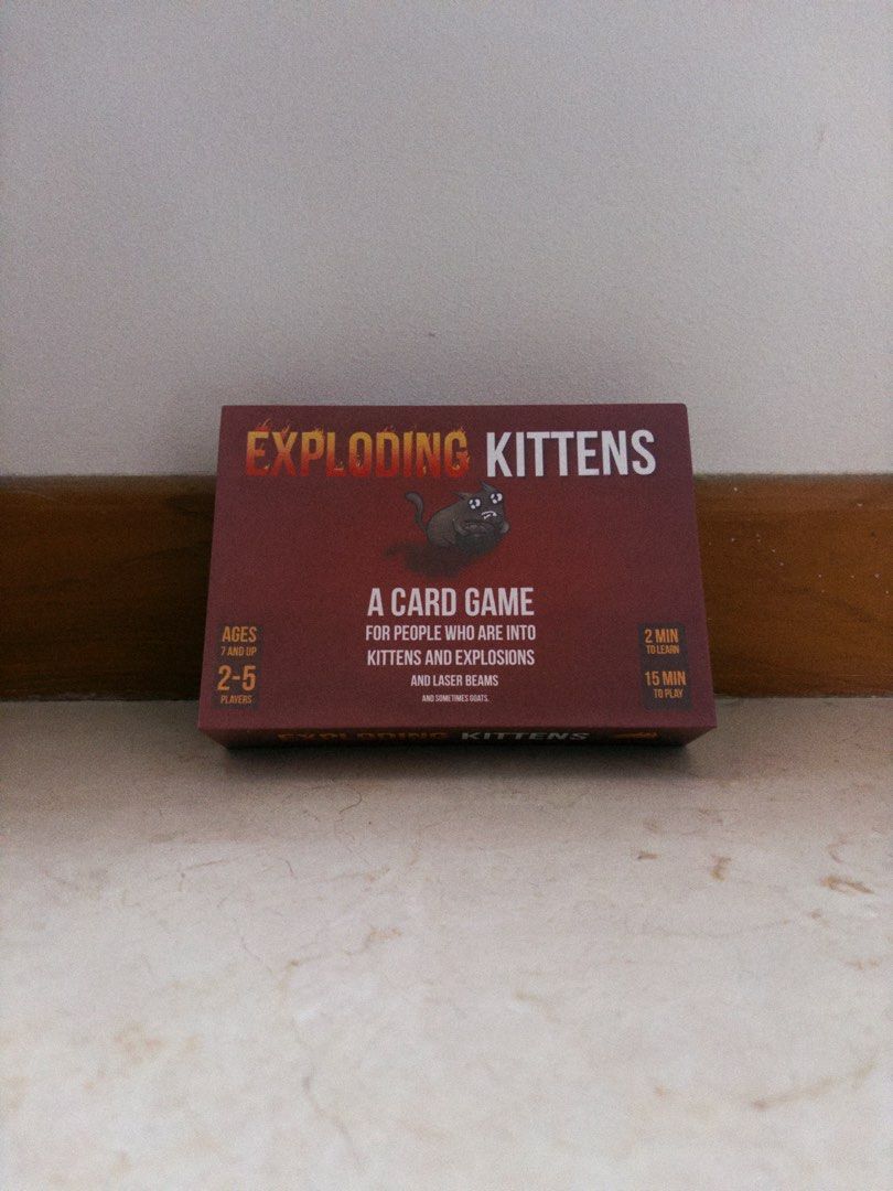 Exploding Kittens Card Game (INCLUDES IMPLODING + STREAKING EXPANSION) (Category: Board Games & Puzzles) located in Singapore. Submitted by tarc_man (Listing ID 1440210058, Image 1). Description: - Exploding Kittens: The card game of strategy and cats! - A kitty-powered version of Russian Roulette. - Draw cards until someone draws an Exploding Kitten and is out. - Last player remaining wins. - Suitable for 2-5 players. - Game time: approximately 