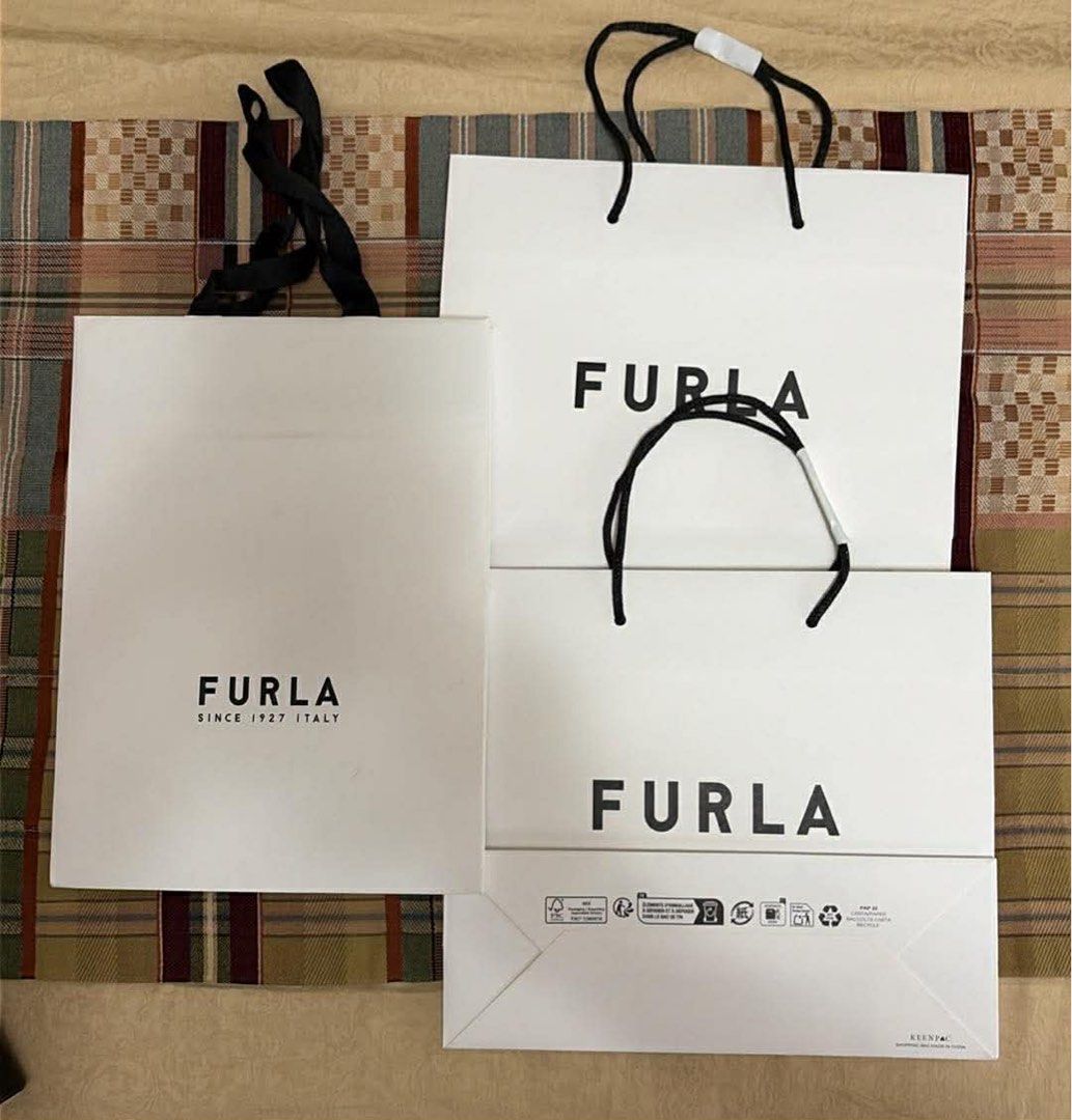 Furla Shopping Bags (Category: Luxury Bags & Wallets) located in Taguig. Submitted by eserehtmil (Listing ID 1440279624, Image 1). Description: - Set of 3 Furla shopping bags - Includes 1 large bag and 2 smaller bags - Color: White with black handles - Features the iconic Furla logo - Ideal for shopping, storage, or as gift bags Take all for 300.