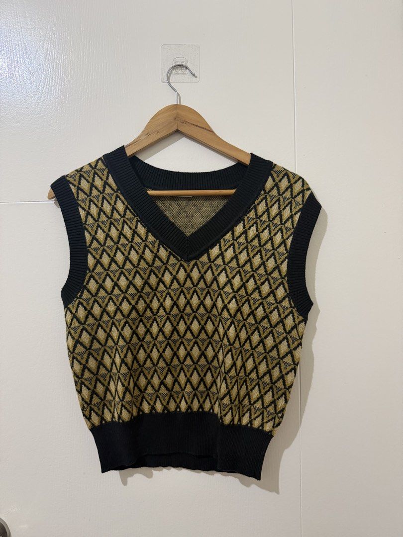 GU Argyle Knit Sweater Vest Size M (Category: Sleeveless) located in Mandaluyong City. Submitted by gemmiebears (Listing ID 1440296235, Image 1). Description: - GU Knit Sweater Vest - Size: Medium (M) - Design: Sleeveless - Pattern: Gold and black argyle - Features: Ribbed trim at neckline, armholes, and hem - Styling: Ideal for layering over shirts or dresses.