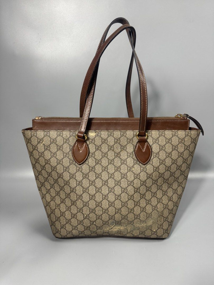 Gucci GG sprim tote bag (Category: Luxury Bags & Wallets) located in Quezon City. Submitted by streetgallerygarments (Listing ID 1440286555, Image 2). Description: Gucci GG Supreme canvas and leather tote bag featuring a top zip Materials: Coated Canvas, Cowhide Leather, and gold-tone metal hardware.Design Features: Flared trapeze silhouette, teardrop-shaped stitched leather handle mounts, a recessed upper zippered compartment, and a prominent br
