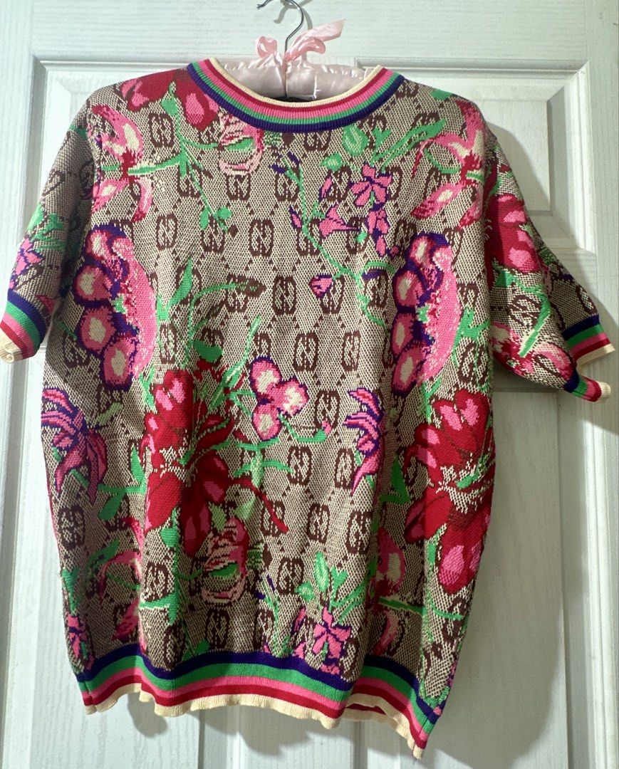 Gucci Monogram Floral Knit Sweater Top (Category: Blouses) located in Cabadbaran. Submitted by KsGoodFind (Listing ID 1440326911, Image 1). Description: - Gucci knit sweater - Ukay source - Features iconic GG monogram and floral print - Short sleeves with ribbed cuffs and hem - Colorful striped neckline detail - Perfect statement piece for any outfit -Fits M-L.