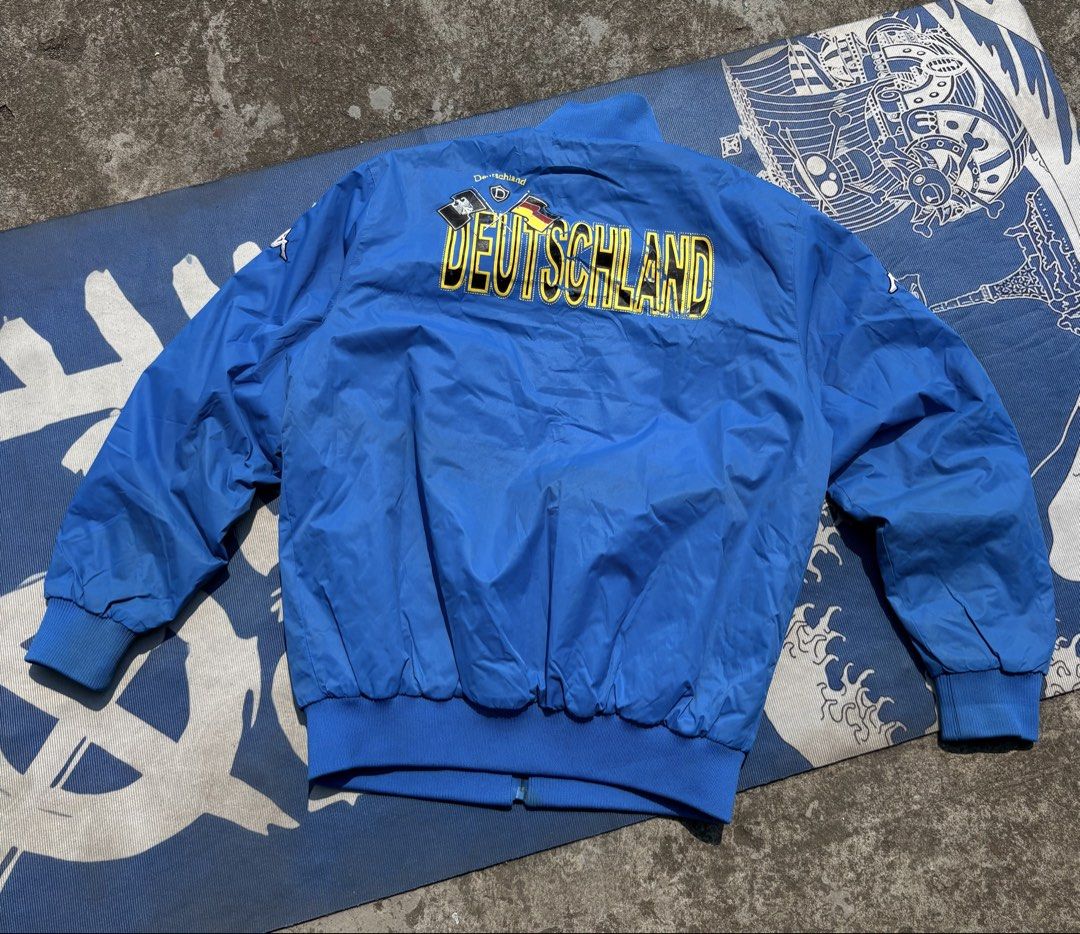 Kappa Germany Deutschland Track Jacket Blue Yellow (Category: Coats, Jackets and Outerwear) located in Manila. Submitted by johnrobert.wolf (Listing ID 1440274549, Image 2). Description: - Authentic Kappa jacket in Germany's iconic colors. - Features bold 'Deutschland' text on the back. - Stylish blue with yellow and white accents. - Full zipper closure for easy wear. - Ribbed cuffs and hem for a comfortable fit. - Ideal for any football enthusia