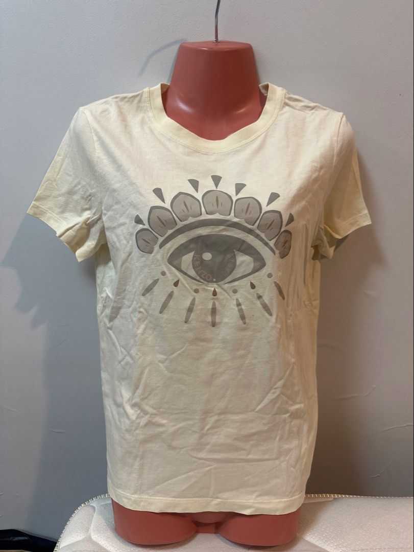 Kenzo Eye Print T-shirt (Category: Shirts) located in Las Pinas. Submitted by Mkdot (Listing ID 1439830532, Image 1). Description: - Kenzo t-shirt - Cream color - Features iconic eye print - Short sleeves - Crew neck - Size tag visible - Plain back - Everyday wear.