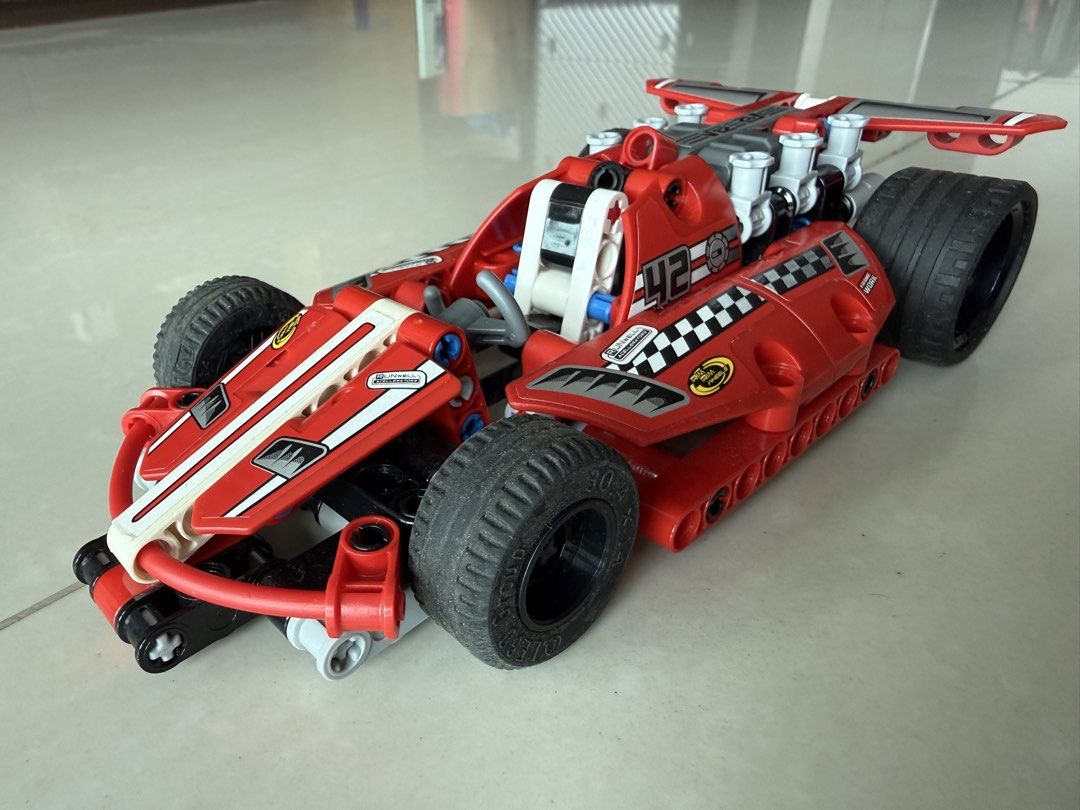 LEGO Technic Red Formula 1 Race Car Set (Category: Toys & Games) located in Singapore. Submitted by plentiful_treasures (Listing ID 1440285569, Image 1). Description: - Red LEGO Technic race car 42011 - Formula 1 inspired design - Features '42' and checkered flag stickers - Detailed V12 engine on top - Chunky black tires - Perfect for building and imaginative play.