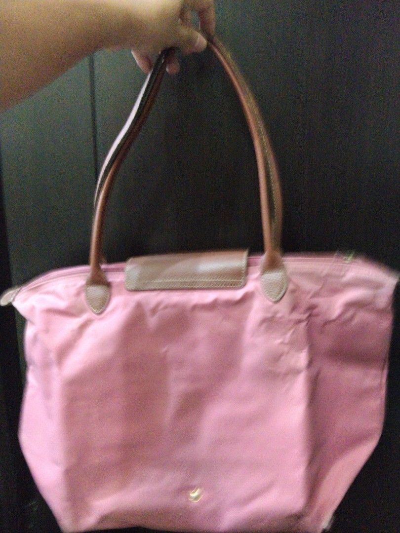 Longchamp Le Pliage Pink Tote Bag (Category: Shoulder Bags) located in Manila. Submitted by rachymae (Listing ID 1440363506, Image 3). Description: - Classic pink Longchamp tote bag - Features elegant leather handles and trim - Folds compactly for easy storage - Ideal for everyday errands or travel - Spacious interior to hold your essentials - Secure closure with zipper and snap button flap all in one listing -minor flaw at the bottom, see pictur