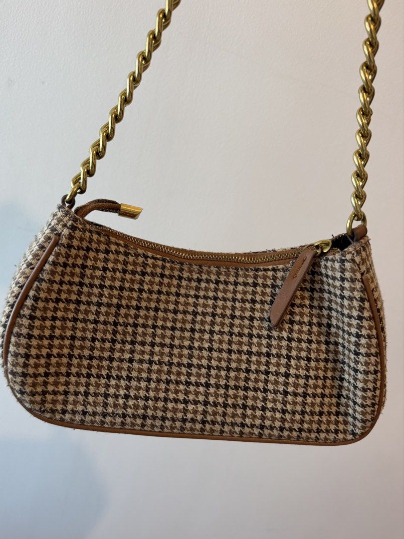 Mango Houndstooth Baguette Bag (Category: Shoulder Bags) located in Manila. Submitted by fdvilla (Listing ID 1440255818, Image 2). Description: - Adorable houndstooth pattern shoulder bag - Features a stylish gold chain strap - Secure zipper closure for your belongings - Elegant brown trim details - Compact size, ideal for carrying essentials - Versatile for casual outings or elevating any outfit - Matches a wide range of fashion styles.