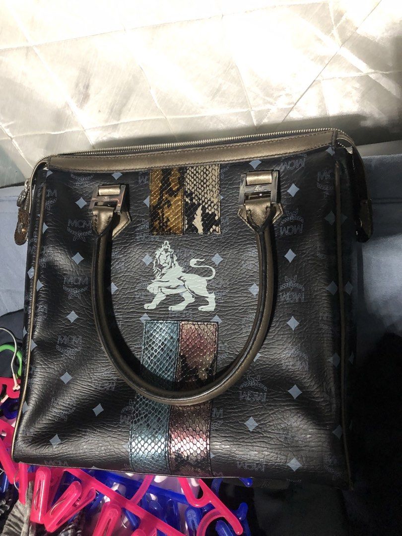 Sale!!!! MCM Lion Print Monogrammed Black Leather Handbag (Category: Luxury Bags & Wallets) located in Pasay City. Submitted by karendgn (Listing ID 1440257597, Image 3). Description: - Authentic MCM monogrammed leather handbag - Eye-catching lion graphic with colorful snake print accents - Convenient top handles for easy carrying - Secure zip closure to keep your belongings safe - Multiple interior compartments for organized storage - Versatile 