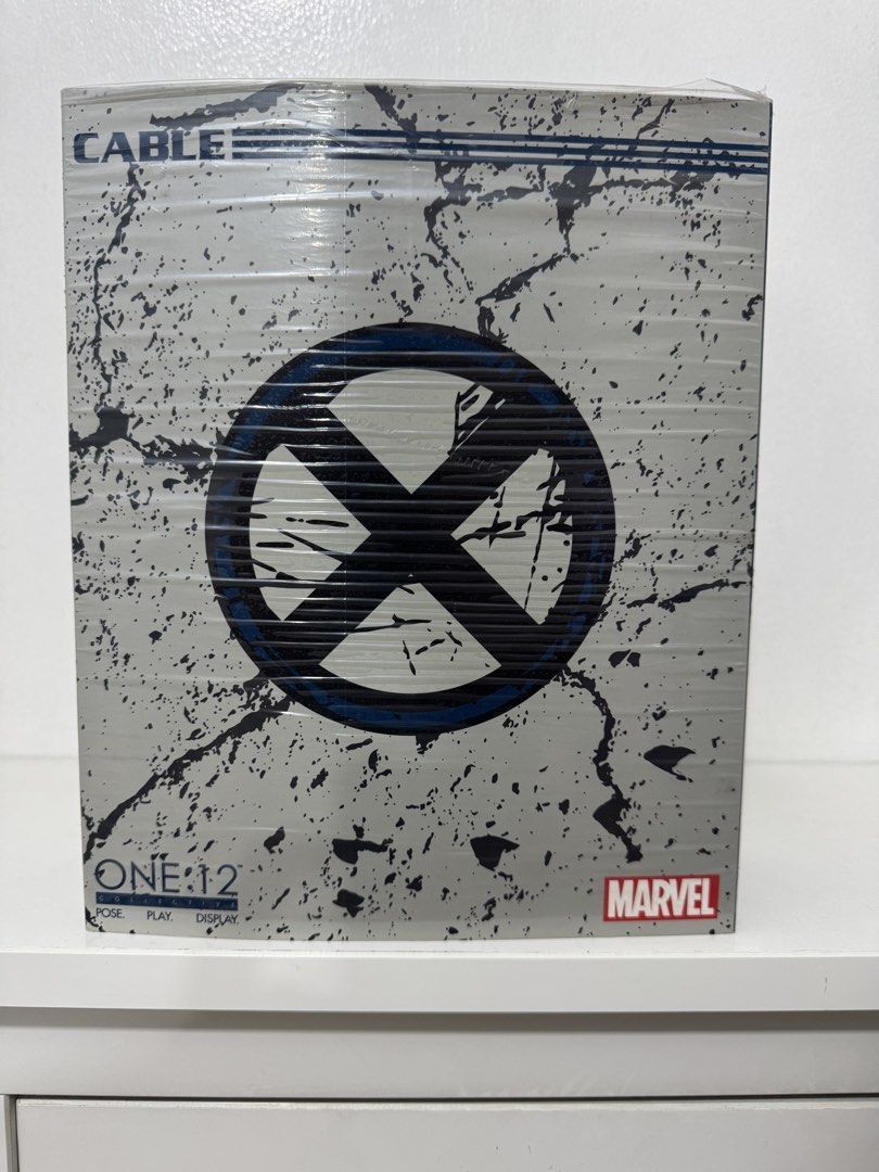 Mezco One:12 Collective Marvel Cable Action Figure Box (Category: Figurines & Statues) located in Manila. Submitted by jos_patrik (Listing ID 1440201369, Image 1). Description: - Mezco One:12 Collective Marvel Cable action figure packaging - Features a distressed, cracked concrete design - Includes the iconic X-Men logo - Still sealed in original plastic - Ideal for display and collection.