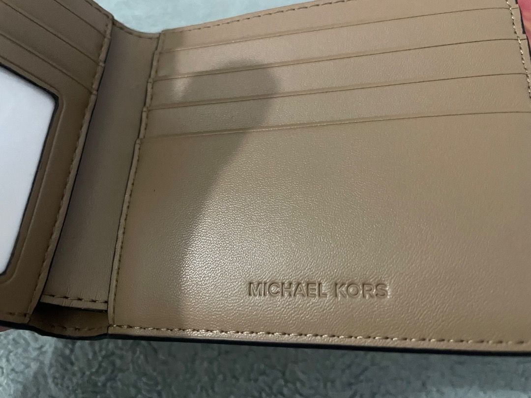 Michael Kors Bifold Wallet (Category: Luxury Bags & Wallets) located in Cebu City. Submitted by michaelbenida (Listing ID 1440277187, Image 3). Description: - Authentic Michael Kors bifold wallet - Classic MK monogram print (fades from white to tan) - Genuine leather lining - Interior card slots and clear ID window - Small and compact design - Ideal for everyday use.
