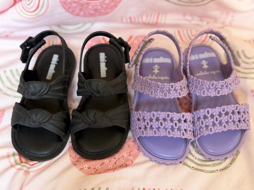 Mini Melissa Isabela Capeto Sandals - Black & Lavender (Category: Babies & Kids Fashion) located in Baguio. Submitted by alexlyone (Listing ID 1440199223, Image 1). Description: Size: US 7 Seldom used Bundle price - Adorable Mini Melissa sandals for your little one. - Available in classic black with a stylish knotted strap. - Charming lavender pair with intricate floral cut-outs. - Comfortable design for all-day wear. - Easy velcro closures for a