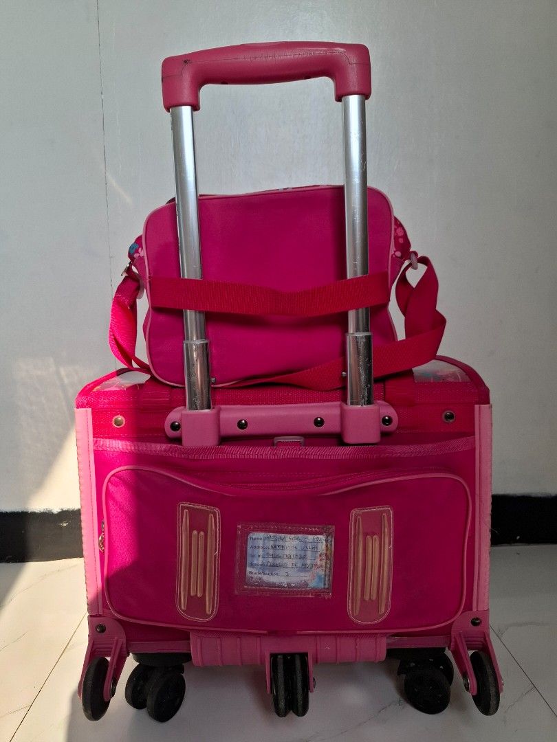 Pink Princess Rolling Luggage Set with Matching Bag (Category: Other Babies Going Out Needs) located in Naic. Submitted by ramatrendph (Listing ID 1440212368, Image 2). Description: - Adorable pink rolling luggage set for kids. - Features beloved Disney Princesses on the front. - Comes with a smaller matching bag that attaches securely to the front. - Equipped with a retractable handle for easy carrying. - Smooth-rolling wheels for effortless tra