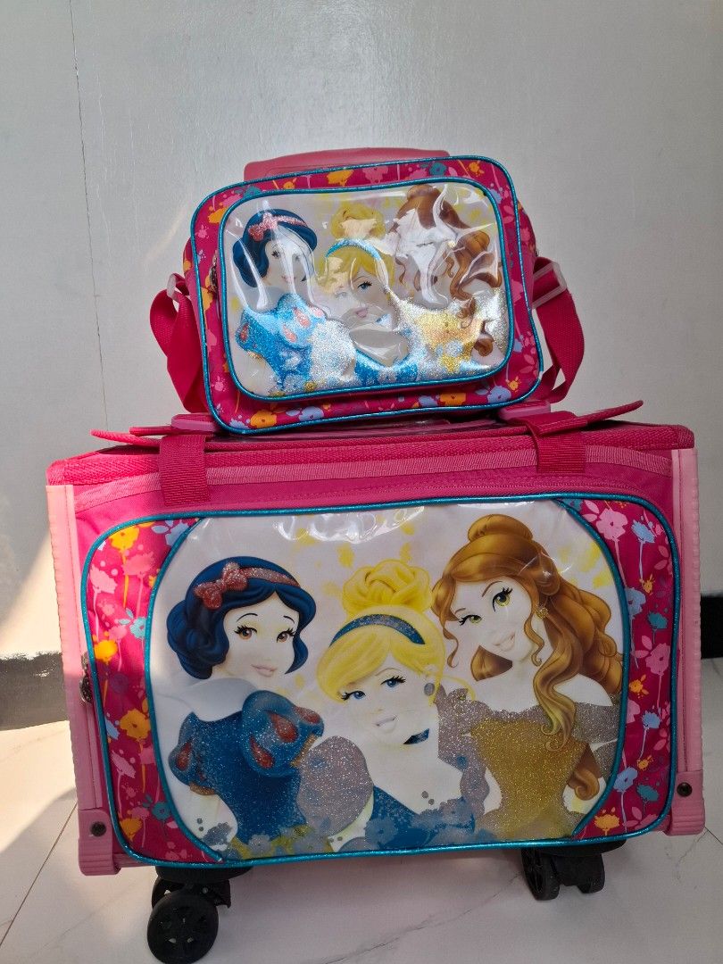 Pink Princess Rolling Luggage Set with Matching Bag (Category: Other Babies Going Out Needs) located in Naic. Submitted by ramatrendph (Listing ID 1440212368, Image 1). Description: - Adorable pink rolling luggage set for kids. - Features beloved Disney Princesses on the front. - Comes with a smaller matching bag that attaches securely to the front. - Equipped with a retractable handle for easy carrying. - Smooth-rolling wheels for effortless tra