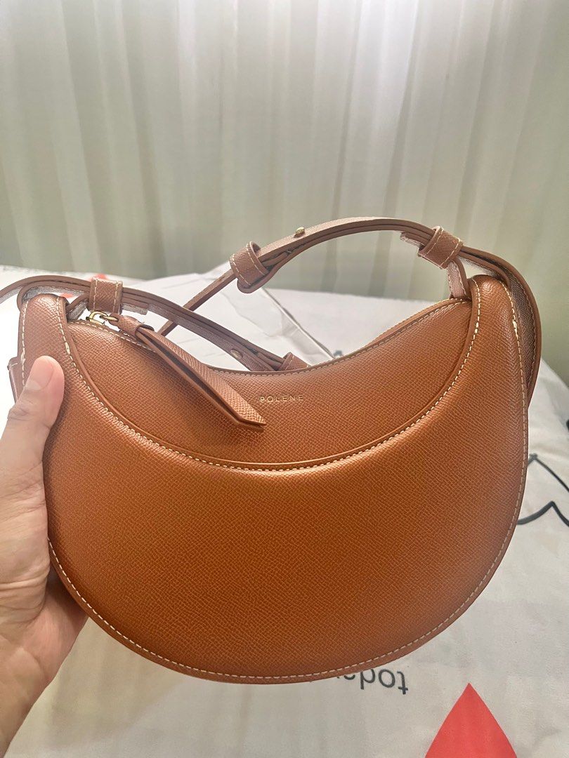 Polène "Numero Dix" Bag in Tan Leather (Category: Shoulder Bags) located in Mandaluyong City. Submitted by marycris89 (Listing ID 1440241216, Image 2). Description: Polene Numero Dix in Tan Leather - No box/Dust bag - In very good condition - Elegant crescent-shaped handbag by Polène. - Crafted from textured tan leather. - Features contrasting white stitching. - Secure zip closure. - Adjustable shoulder strap for versatile styling. - Interior sli