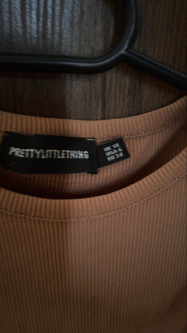 PrettyLittleThing Ribbed Crop Tank Top (Category: Sleeveless) located in Manila. Submitted by koalexp38471 (Listing ID 1440299636, Image 2). Description: - Brand: PrettyLittleThing - Style: Brown ribbed crop tank top - Features: Sleeveless, racerback design - Material: Comfortable and stretchy - Versatile: Great for layering or wearing on its own - Pairing: Easy to match with jeans or shorts.