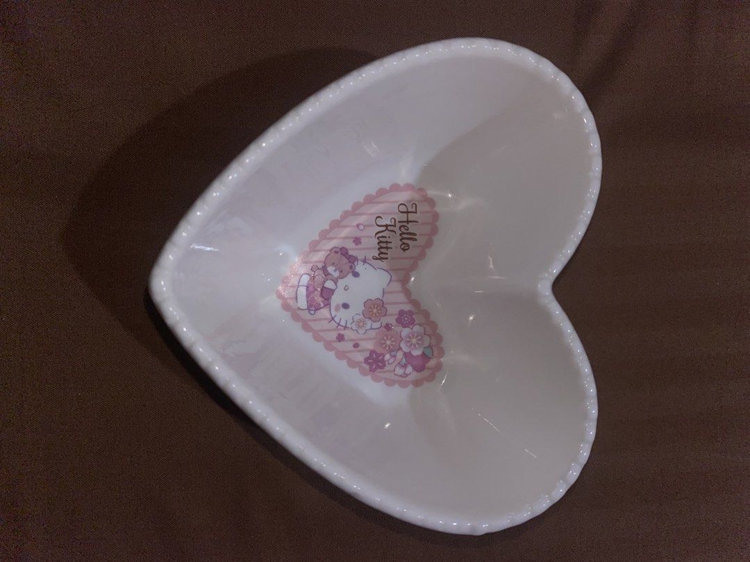Sanrio Hello Kitty Heart Shaped Dish (Category: Other Kitchenware & Tableware) located in Manila. Submitted by dianaclutz (Listing ID 1440238203, Image 2). Description: - Adorable heart-shaped dish featuring Kitty and a teddy bear. - Perfect for storing trinkets, jewelry, or as a decorative accent. - Made from durable ceramic material. - Microwave and dishwasher safe for easy cleaning and use. -Branded Hello Kitty Sanrio 2021 Vintage - Microwave 