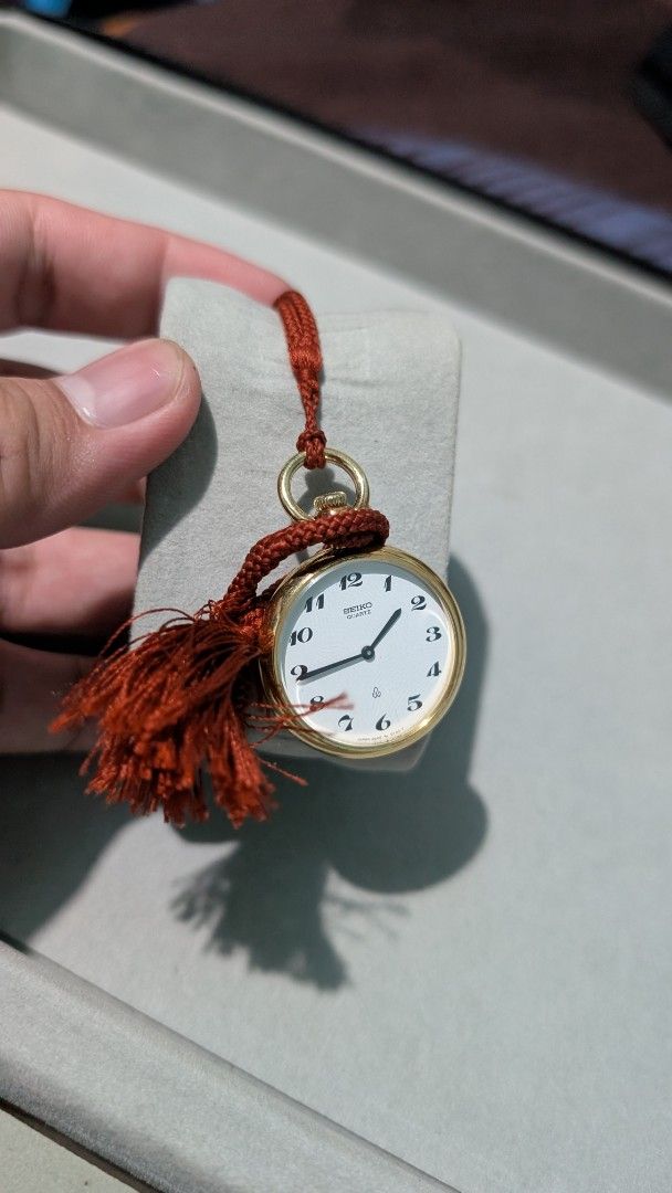 Seiko Quartz Pocket Watch with Tassel (Category: Men's Watches) located in Manila. Submitted by kingractis62231 (Listing ID 1440377185, Image 3). Description: - Gold-tone Seiko pocket watch - White dial with black Arabic numerals - Reliable quartz movement - Comes with a red braided cord and tassel - Working condition - Ideal for collectors or as a unique fashion statement.