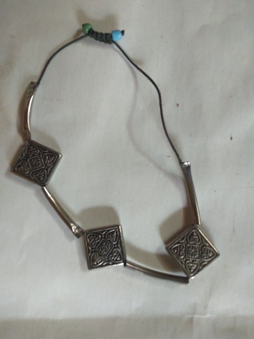 Silver Tone Bracelet with Square Ornate Charms (Category: Bracelets) located in Davao. Submitted by bravemoon_556cd5 (Listing ID 1440286435, Image 2). Description: - Silver tone bracelet - Features three square charms with intricate patterns - Adjustable cord closure with small bead accents - Unique design to add flair to your outfit.