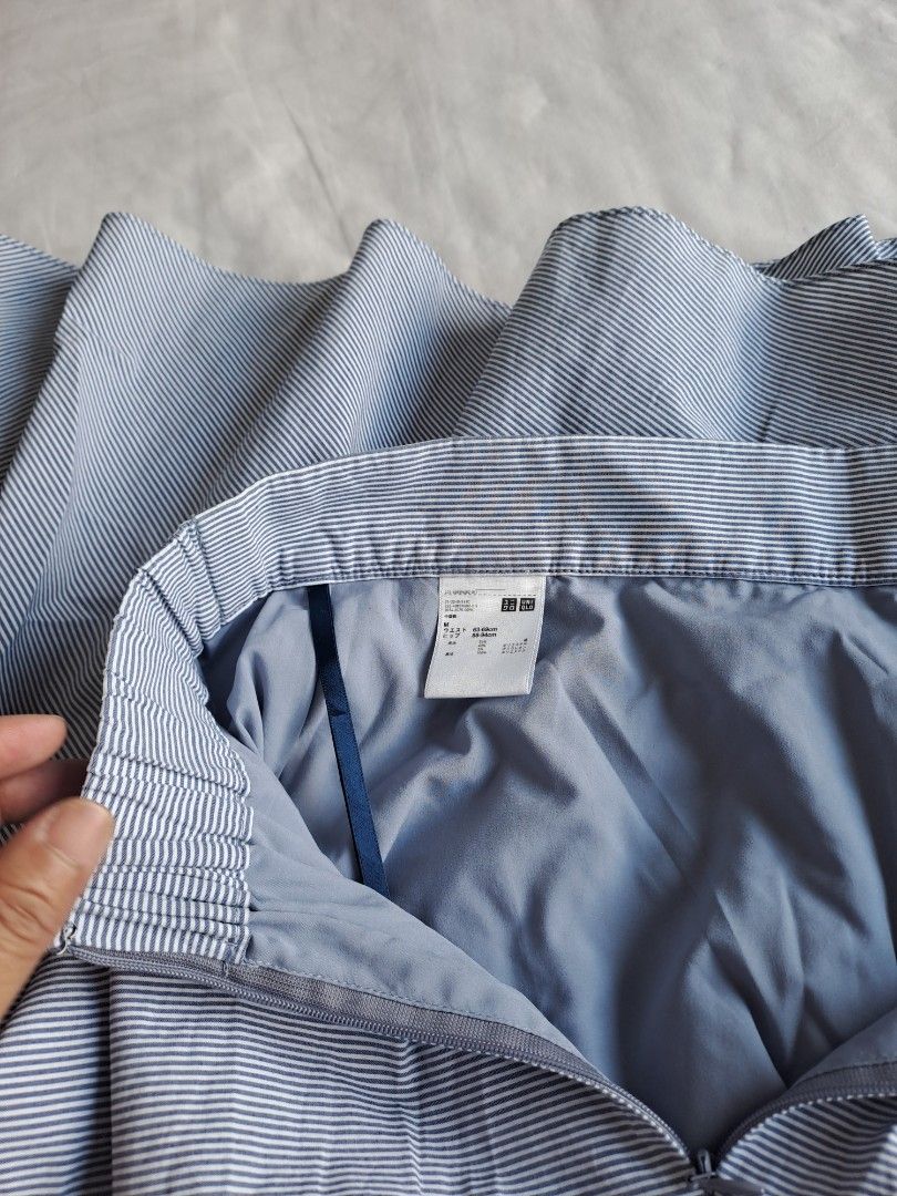 UNIQLO STRIPE SKIRT (Category: Skirts) located in Manila. Submitted by joanbalde39643 (Listing ID 1440280328, Image 3). Description: The selected item is a Uniqlo Highwaisted Blue & White Striped Circular Skirt. It features a fine seersucker pinstripe pattern, a partially elasticized gathered back waistband, a side zipper closure, inner lining, and integrated fabric hanger loops.Style and Care ProfileDesign Elements: Flared A-line silhouette, hig