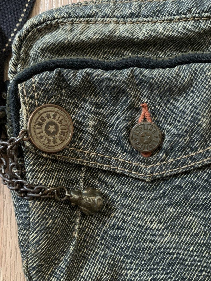 Vintage Kipling Denim Mini Crossbody Bag with Monkey Charm (Category: Cross-body Bags) located in Manila. Submitted by riki_won09 (Listing ID 1440234524, Image 3). Description: - Cute Kipling crossbody bag - Washed-out denim material - Front pocket with button closure and chain detail - Interior with striped lining and zippered pocket - Adjustable strap for comfortable wear - Ideal for everyday use and fashion.