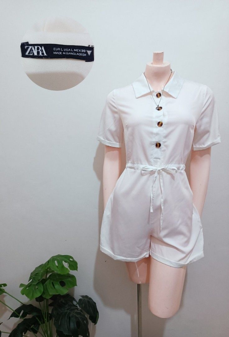 Zara White Button-Down Short Romper with Tie Waist (Category: Rompers) located in Angeles City. Submitted by leichen57360 (Listing ID 1440235904, Image 1). Description: - Chic white romper from Zara - Perfect for a stylish casual look - Classic button-down front - Short sleeves - Flattering tie waist - Collared neckline - Convenient side pockets - Made in Bangladesh.