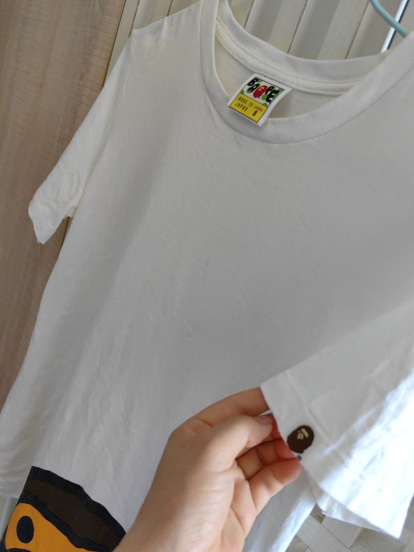 BAPE 猿人頭圖案短袖Tee(S-M) （分類：T-shirt、恤衫、有領衫）位於 Hong Kong。 由 camellia6688 提交（商品編號 1440462153，圖片 3）。簡介： BAPE 經典猿人頭圖案Tee，白色短袖款。標碼S,略偏大,M亦可著,Made in Japan。衫身印有可愛嘅猿人頭，好有辨識度。袖口位仲有小猿人頭鈕扣細節。。