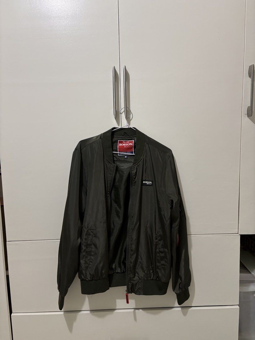 Bobson Olive Green Bomber Jacket Size M (Category: Coats, Jackets and Outerwear) located in Pasig City. Submitted by grumpycat15 (Listing ID 1440493376, Image 1). Description: - Bobson Olive Green Bomber Jacket - Made in Japan - Size: Medium (M) - Classic bomber style with ribbed cuffs and hem - Lightweight material, ideal for layering - Perfect for casual wear - Please check photos for detailed condition.