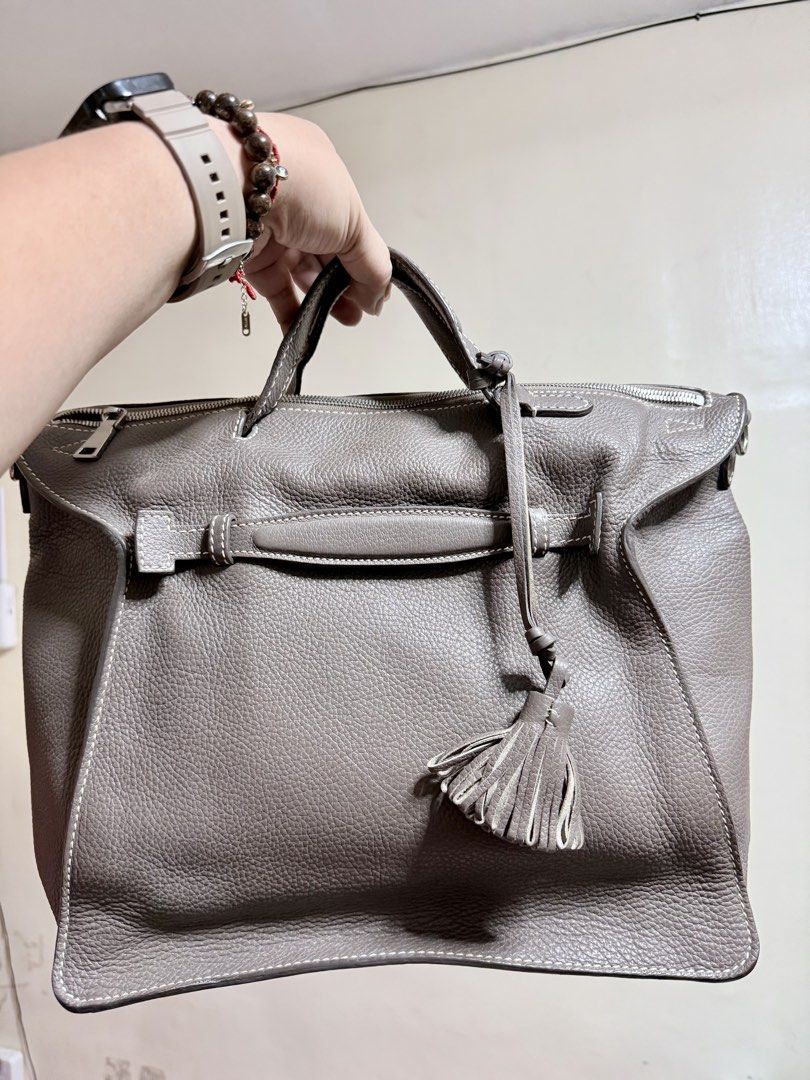 Daniel Hechter Paris Leather Handbag Taupe (Category: Luxury Bags & Wallets) located in Cavite. Submitted by lady_speculator_ph (Listing ID 1440575705, Image 1). Description: - Authentic Daniel Hechter Paris handbag in a stylish taupe color. - Crafted from textured leather with elegant white stitching details. - Secure top zipper closure for your belongings. - Convenient interior zippered pocket for essentials. - Adorable tassel detail on the fro