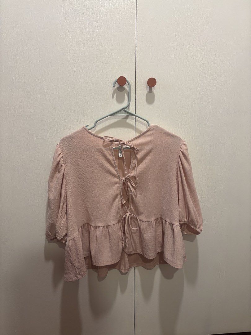 DIVIDED Pink Peplum Tie-Back Top Size L (Category: Sleeveless) located in Muntinlupa City. Submitted by beacq (Listing ID 1440471599, Image 1). Description: - Cute pink peplum top from DIVIDED - Features puff sleeves and a ruffled hem - Stylish tie-back detail at the neck - Versatile for pairing with jeans or skirts - Comfortable and chic for everyday wear.