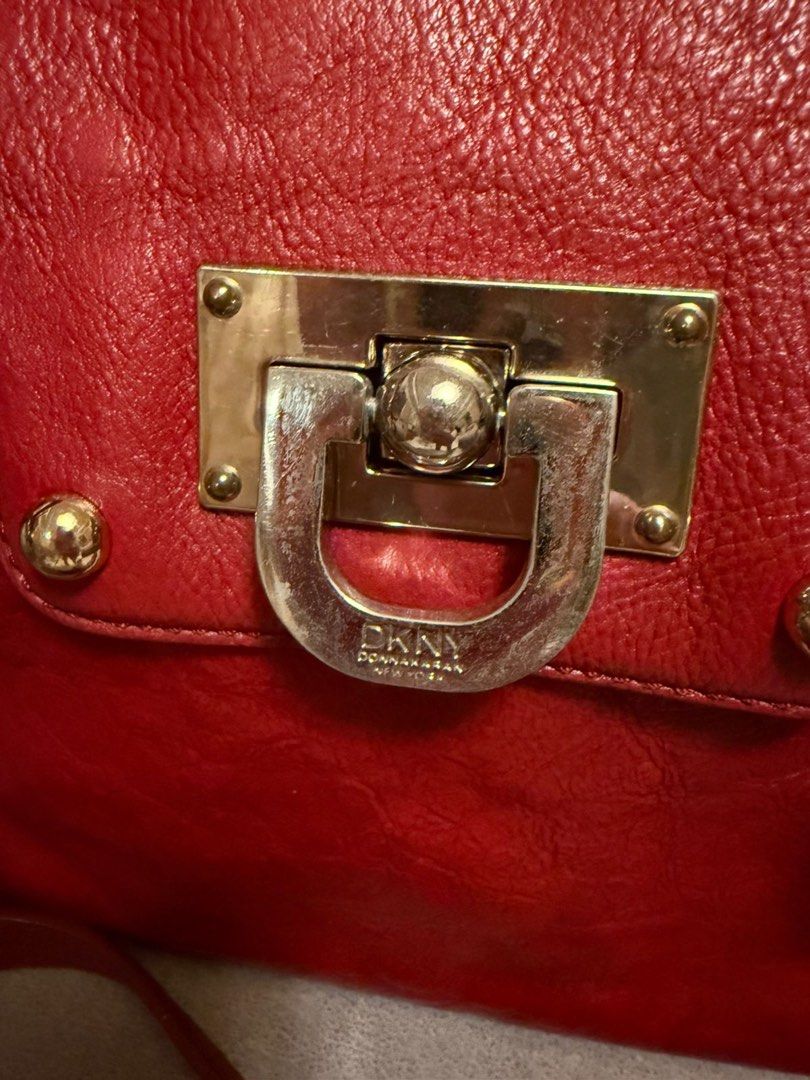 DKNY Red Leather Satchel Bag with Shoulder Strap (Category: Shoulder Bags) located in Davao. Submitted by mmc1521 (Listing ID 1440524451, Image 3). Description: - Genuine red leather DKNY handbag - Versatile with top handles and a detachable shoulder strap - Elegant gold hardware details - Spacious interior with multiple compartments - Includes a secure zippered pocket - Interior is clean and well-maintained - Ideal for everyday wear and style Fr