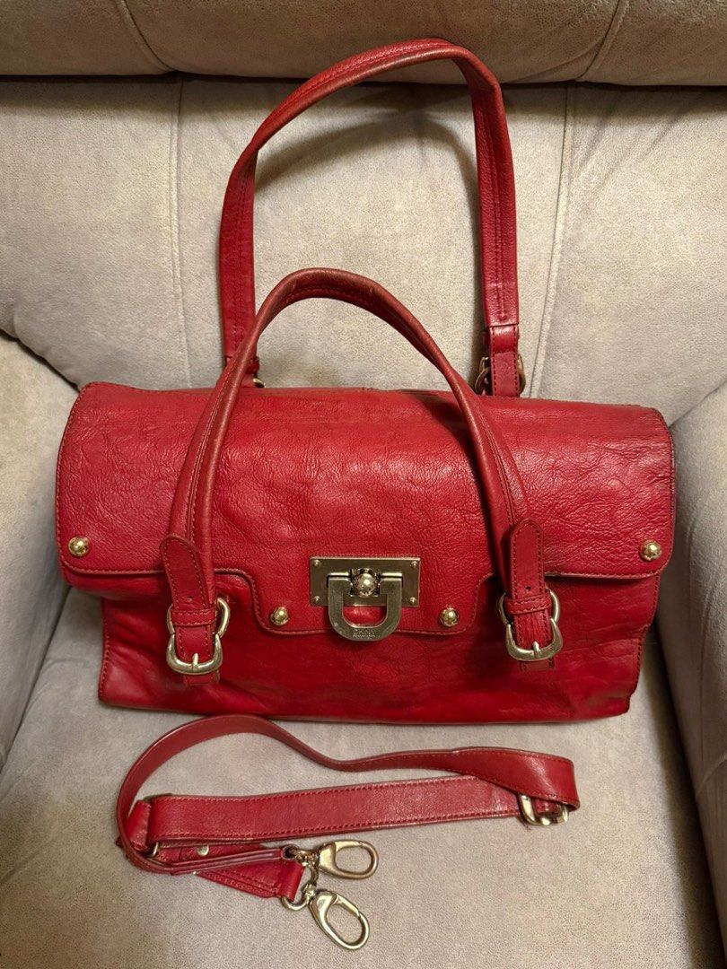 DKNY Red Leather Satchel Bag with Shoulder Strap (Category: Shoulder Bags) located in Davao. Submitted by mmc1521 (Listing ID 1440524451, Image 2). Description: - Genuine red leather DKNY handbag - Versatile with top handles and a detachable shoulder strap - Elegant gold hardware details - Spacious interior with multiple compartments - Includes a secure zippered pocket - Interior is clean and well-maintained - Ideal for everyday wear and style Fr