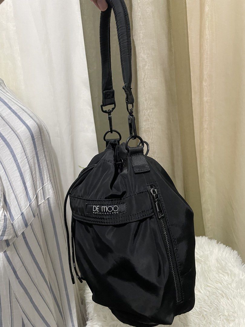 DÉMOO Parkchoonmoo Black Nylon Drawstring Bucket Bag (Category: Shoulder Bags) located in Cabanatuan. Submitted by moraiahraven (Listing ID 1440521449, Image 2). Description: Black Nylon Drawstring Bucket Bag by DÉMOO (Parkchoonmoo) Stylish and functional black drawstring bucket bag in lightweight, durable nylon. Features a relaxed slouchy silhouette with a secure drawstring closure and convenient front zip pocket. Key Features: • Padded shoulder