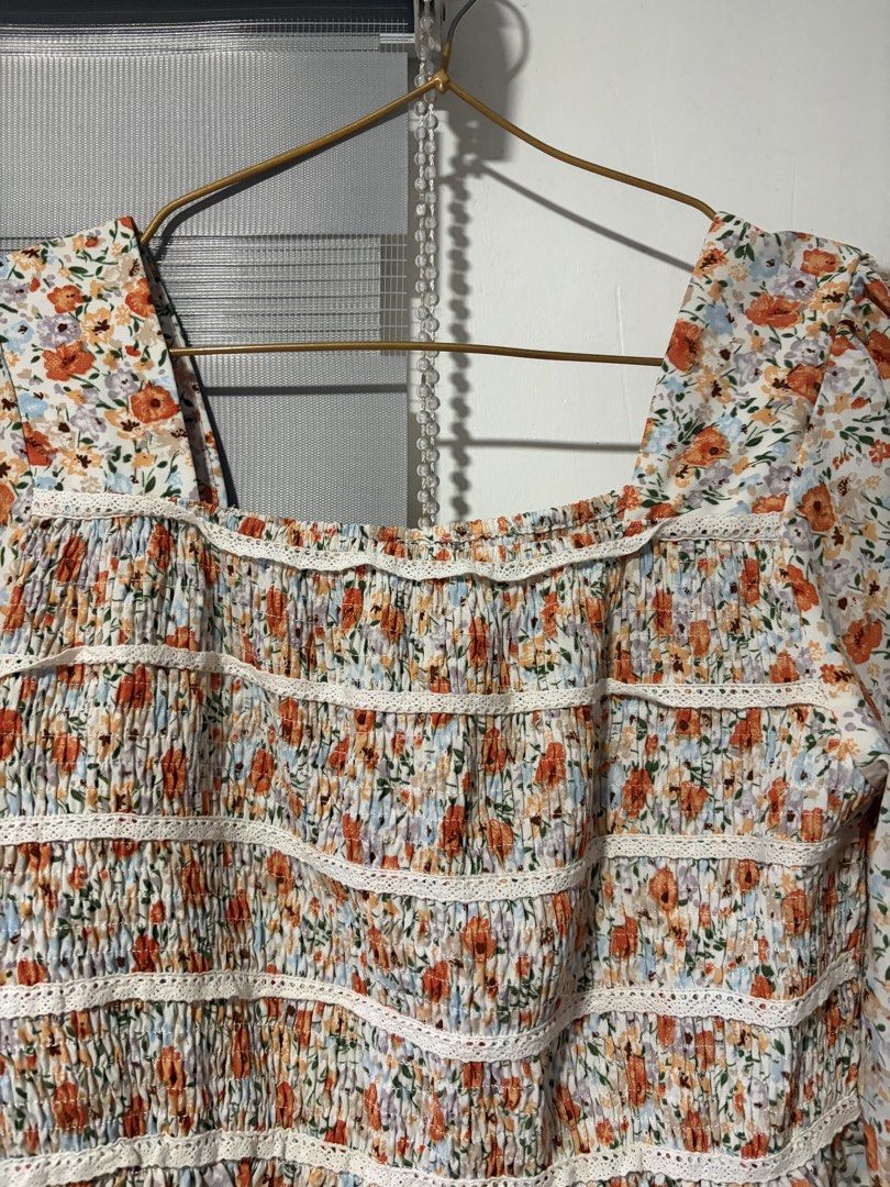 Floral Smocked Square Neck Peplum Top (Category: Sleeveless) located in Pasay City. Submitted by aisozstudio (Listing ID 1440514589, Image 2). Description: - White top with ditsy floral print (orange & blue) - Smocked bodice with delicate lace trim - Flattering square neckline - Trendy long puff sleeves with ruffled cuffs - Flowy peplum hemline - Perfect for a cute and breezy look - Can fit to small to medium.