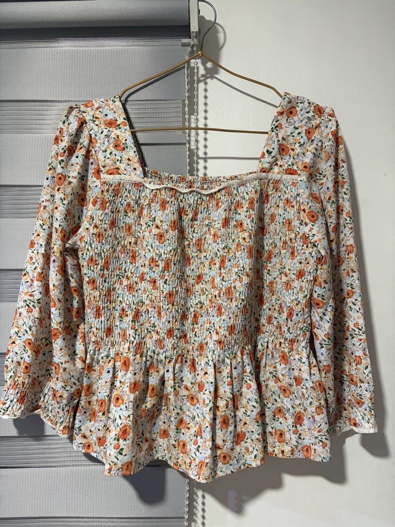 Floral Smocked Square Neck Peplum Top (Category: Sleeveless) located in Pasay City. Submitted by aisozstudio (Listing ID 1440514589, Image 1). Description: - White top with ditsy floral print (orange & blue) - Smocked bodice with delicate lace trim - Flattering square neckline - Trendy long puff sleeves with ruffled cuffs - Flowy peplum hemline - Perfect for a cute and breezy look - Can fit to small to medium.