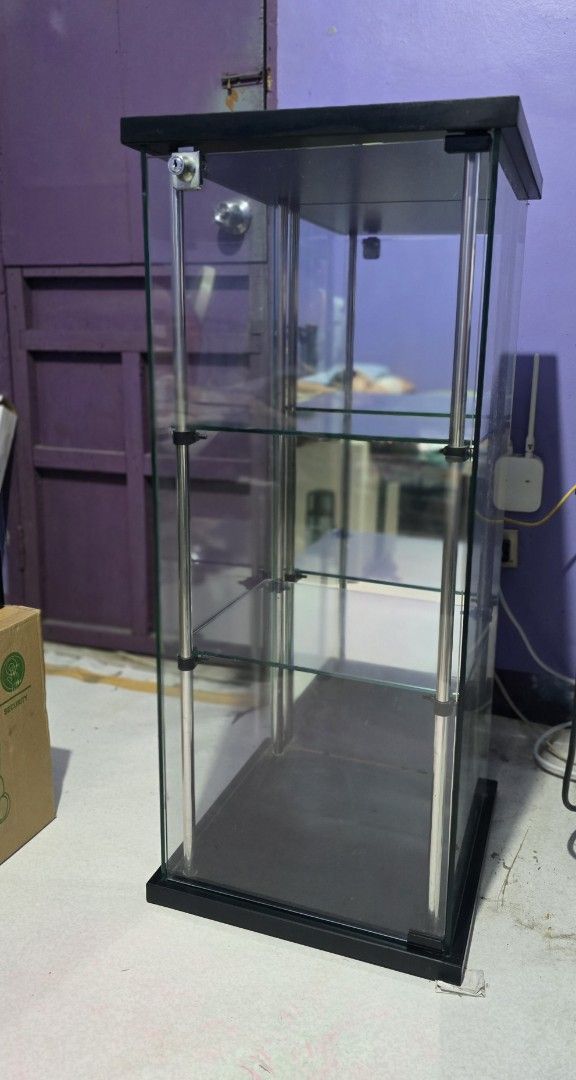 Glass Display Cabinet with Shelves (Category: Shelves, Cabinets & Racks) located in Rizal. Submitted by whitehole94 (Listing ID 1440572799, Image 1). Description: - Tall glass display cabinet (approx. 6ft) - Multiple glass shelves for storage/display - Sleek black frame and base - Doors open and close smoothly - Ideal for collectibles or retail items - Pick up only.