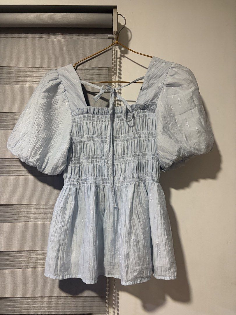 Light Blue Puff Sleeve Smocked Square Neck Top (Category: Blouses) located in Pasay City. Submitted by aisozstudio (Listing ID 1440514229, Image 3). Description: - Cute light blue top - Square neckline - Smocked bodice - Puff sleeves for volume - Ties at the back - Fabric with a subtle shimmer - Perfect for dressing up or down.