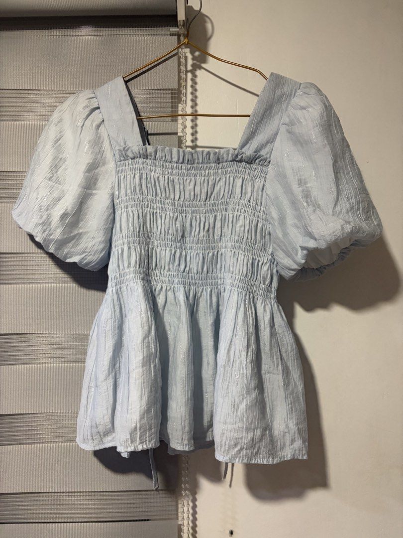 Light Blue Puff Sleeve Smocked Square Neck Top (Category: Blouses) located in Pasay City. Submitted by aisozstudio (Listing ID 1440514229, Image 1). Description: - Cute light blue top - Square neckline - Smocked bodice - Puff sleeves for volume - Ties at the back - Fabric with a subtle shimmer - Perfect for dressing up or down.