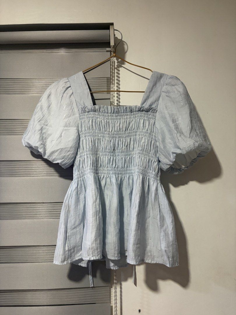 Light Blue Puff Sleeve Smocked Square Neck Top (Category: Blouses) located in Pasay City. Submitted by aisozstudio (Listing ID 1440514229, Image 2). Description: - Cute light blue top - Square neckline - Smocked bodice - Puff sleeves for volume - Ties at the back - Fabric with a subtle shimmer - Perfect for dressing up or down.