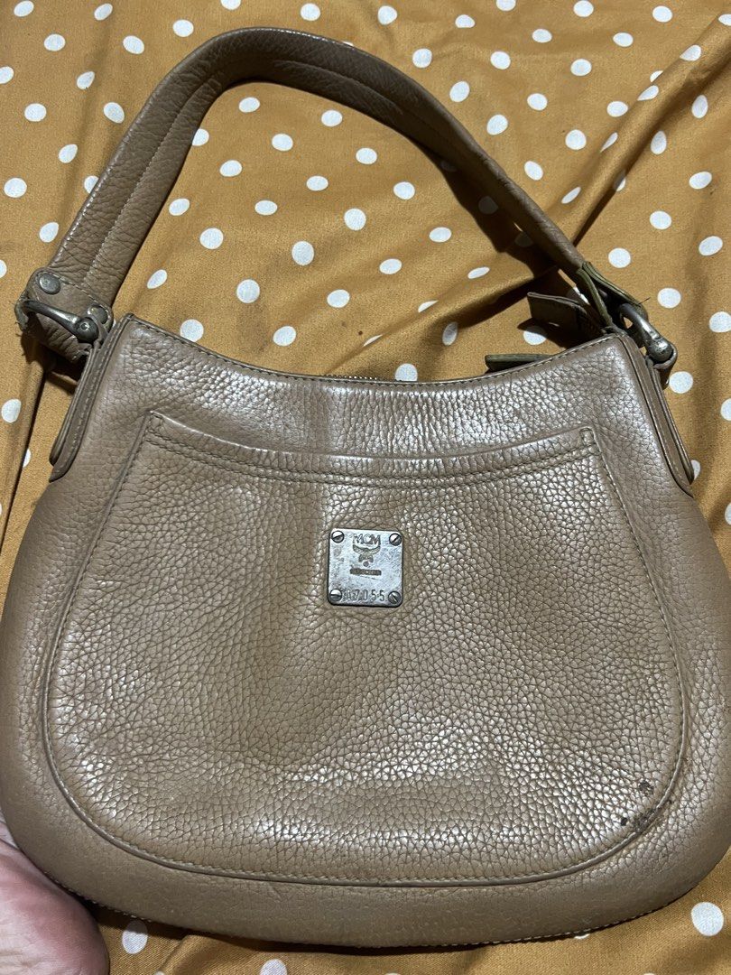 MCM München Leather Hobo Shoulder Bag (Category: Luxury Bags & Wallets) located in Manila. Submitted by jaisailove68397 (Listing ID 1440555381, Image 1). Description: - Authentic MCM München Hobo Bag - Color: Taupe/Light Brown - Material: Pebbled Leather - Closure: Zipper - Interior: 1 Zippered Pocket - Strap: Adjustable with buckle - Style: Classic, everyday bag.