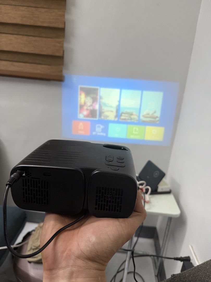 Mini Projector (Category: Soundbars, Speakers & Amplifiers) located in Bulacan. Submitted by mysticdeer.6d7f47 (Listing ID 1440547006, Image 2). Description: This is a Jimveo C11 or E11 mini portable projector.Resolution: It supports a Full HD 1080P resolution for clear viewing.Connectivity: The projector features WiFi capability and Bluetooth for wireless streaming from smartphones.Portability: It is designed as a compact, “ultra-small” unit sui
