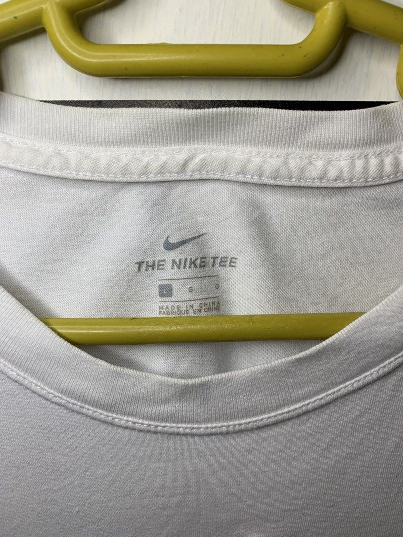 Nike Tee White T-Shirt with Red Lips Logo (Category: Tshirts & Polo Shirts ) located in Manila. Submitted by pole.thirft (Listing ID 1440492004, Image 2). Description: - White Nike t-shirt - Features iconic Nike logo - Small red lips graphic on chest - Tag reads 'The Nike Tee' - Size: Large (L) - Made in China - Ideal for everyday casual wear.