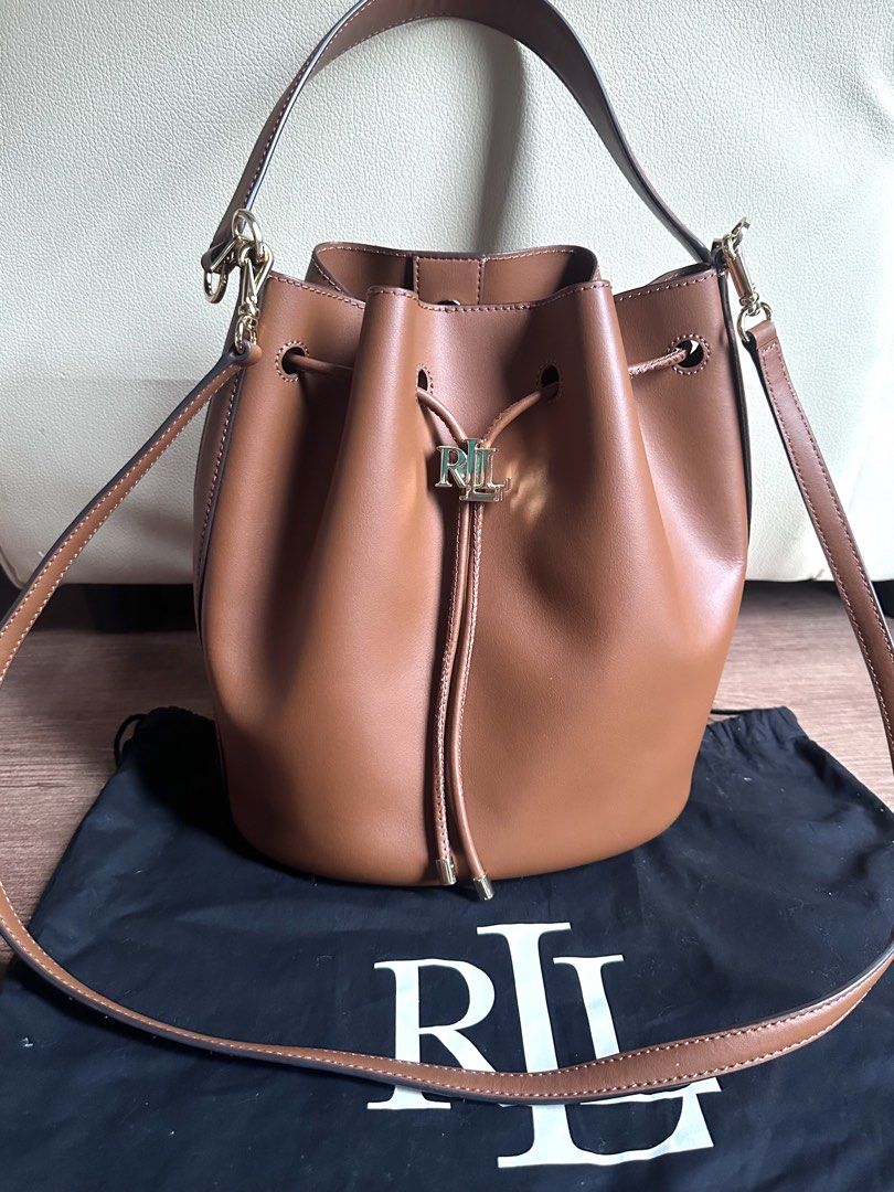Original Ralph Lauren Medium Bucket Bag (Category: Luxury Bags & Wallets) located in Manila. Submitted by amethyste_ph (Listing ID 1438308363, Image 1). Description: Stylish bucket bag from Lauren Ralph Lauren. It features a drawstring closure and a top handle. The bag is a warm brown color and includes a dust bag. The bag has a gold-tone logo detail..