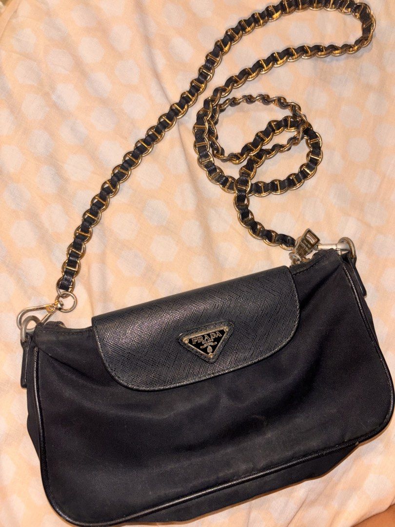 Prada Black Nylon Chain Shoulder Bag (Category: Luxury Bags & Wallets) located in Apalit. Submitted by trinaaa25 (Listing ID 1440453334, Image 2). Description: - Authentic Prada Bag - Color: Black - Material: Nylon with Saffiano Leather flap - Features: Gold chain strap, Zipper closure, Multiple interior compartments.