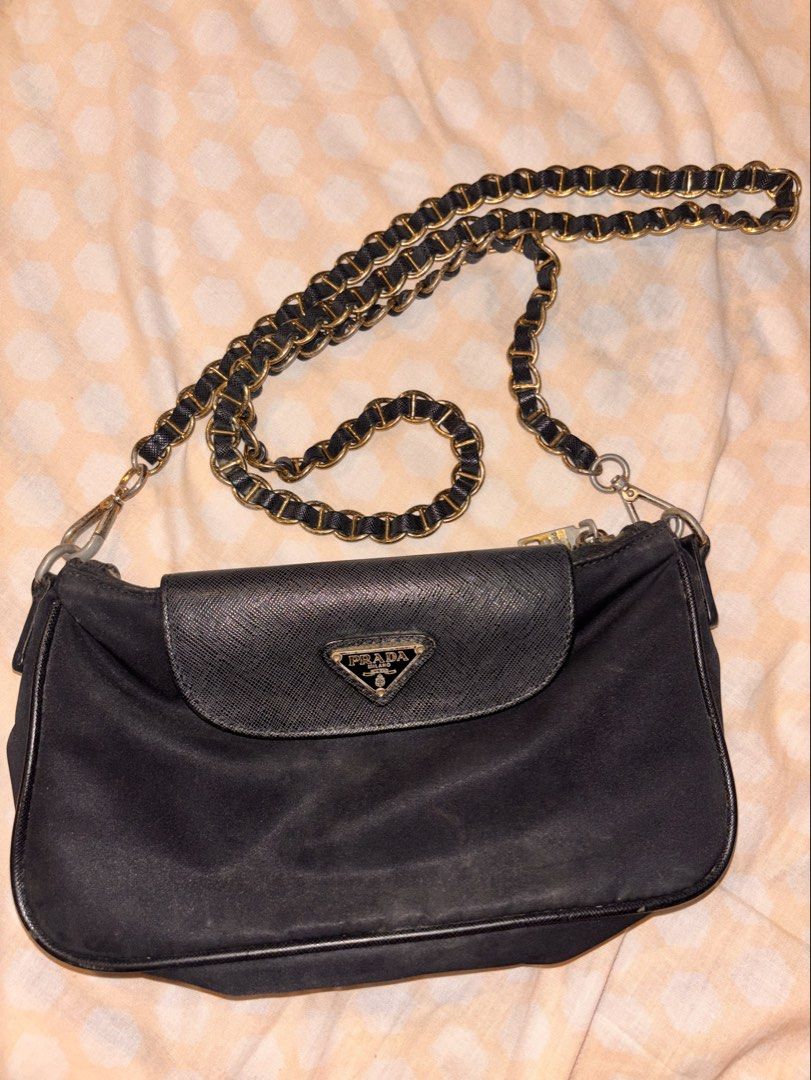 Prada Black Nylon Chain Shoulder Bag (Category: Luxury Bags & Wallets) located in Apalit. Submitted by trinaaa25 (Listing ID 1440453334, Image 1). Description: - Authentic Prada Bag - Color: Black - Material: Nylon with Saffiano Leather flap - Features: Gold chain strap, Zipper closure, Multiple interior compartments.