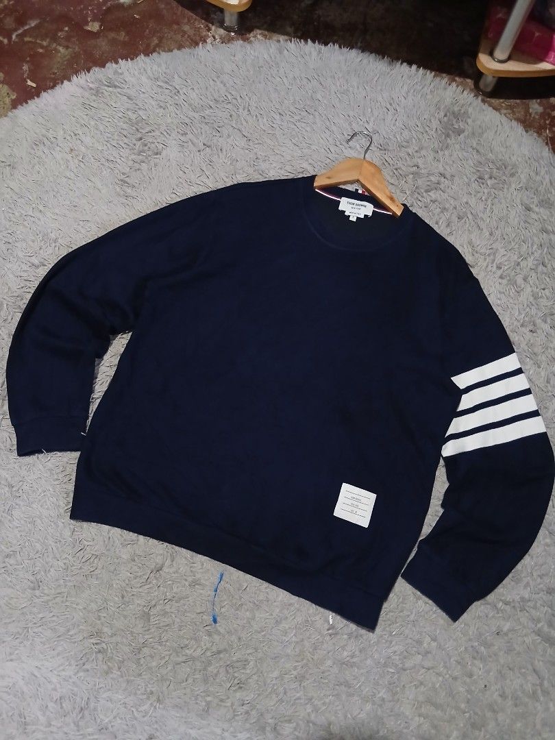 Thom Browne Navy Sweatshirt with White Stripe (Category: Luxury Apparel) located in Davao. Submitted by marissasof29286 (Listing ID 1440452220, Image 2). Description: -Classic Navy Sweatshirt from Thom Browne -Features Signature White Stripes on the sleeve -Small woven label detail -Made in Italy -Perfect for a stylish casual look -Size 4 Large to XL fit -Dimes 22x27 -Color rate 9.5/10 No issue.