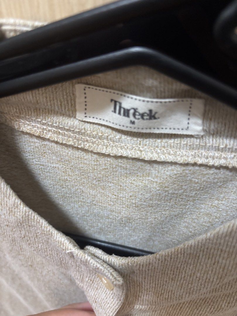 Threek Beige Button-Up Short Sleeve Top Size M (Category: Blouses) located in Pasig City. Submitted by smgss (Listing ID 1440401435, Image 2). Description: - Beige top from Threek - Size: M - Short sleeves - Button-up front - Mandarin collar - Subtle textured fabric - Versatile for casual or dressed-up occasions.