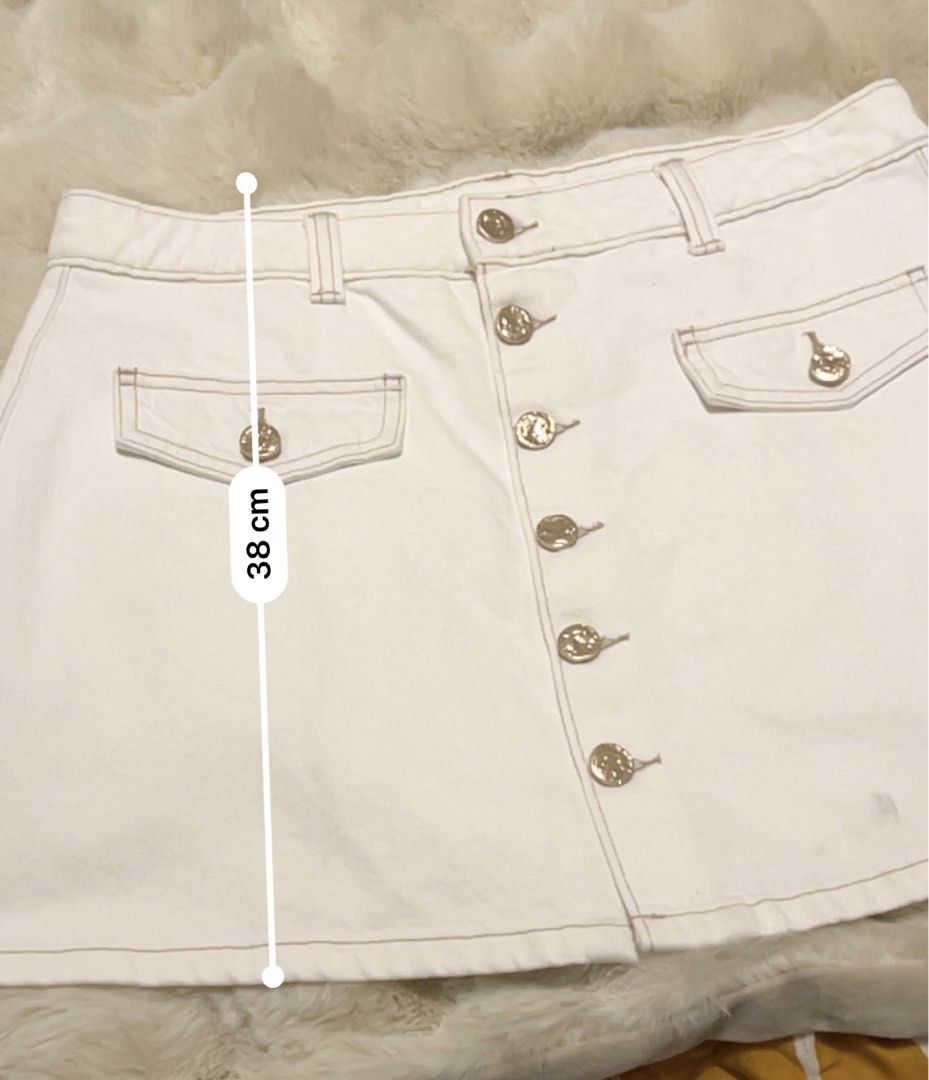 White Button-Front Denim Skirt with Gold Buttons (Category: Skirts) located in Pasig City. Submitted by royalregistry (Listing ID 1440474562, Image 2). Description: - Brandnew. Bought in Australia - Classic white denim skirt - Button-front closure with elegant gold-tone buttons - Two functional front pockets with button closures - One convenient back pocket - Attractive stitching detail throughout - Measurements: Waist 44cm, Length 38cm.