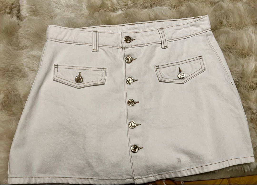 White Button-Front Denim Skirt with Gold Buttons (Category: Skirts) located in Pasig City. Submitted by royalregistry (Listing ID 1440474562, Image 3). Description: - Brandnew. Bought in Australia - Classic white denim skirt - Button-front closure with elegant gold-tone buttons - Two functional front pockets with button closures - One convenient back pocket - Attractive stitching detail throughout - Measurements: Waist 44cm, Length 38cm.